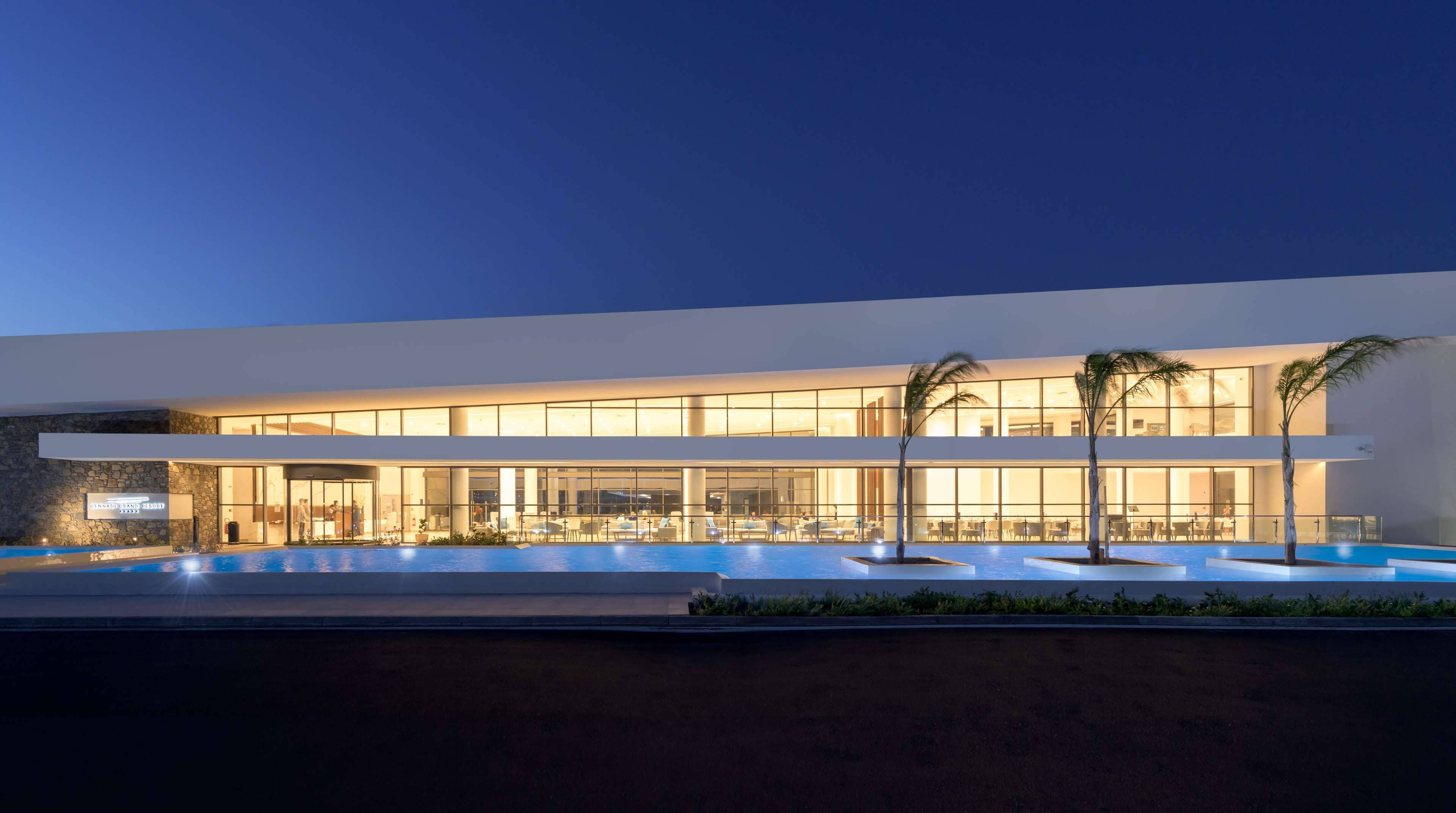 A modern hotel with a large pool area and multiple dining areas.
