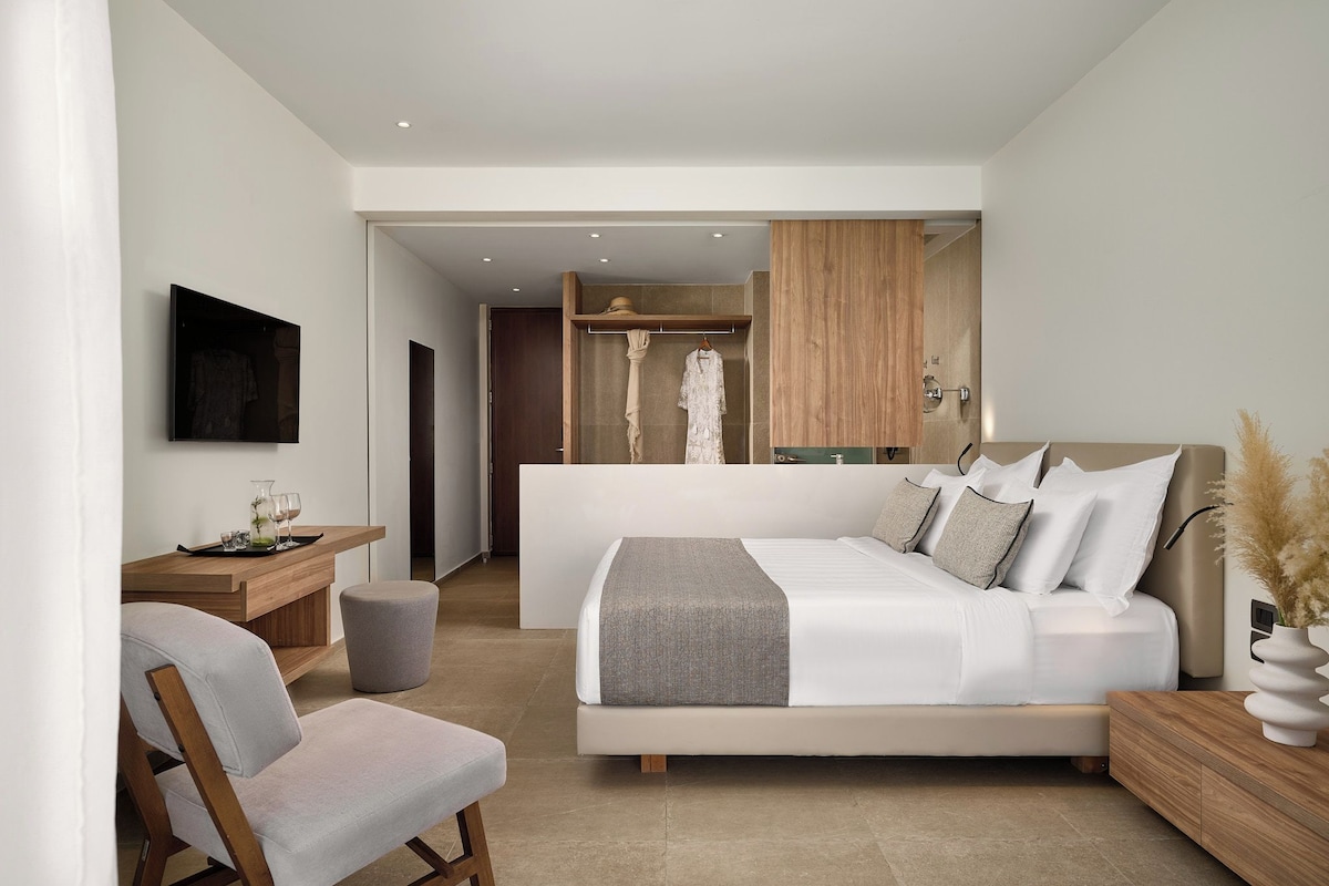 Une chambre moderne avec un grand lit, une table de chevet, une chaise et une armoire.