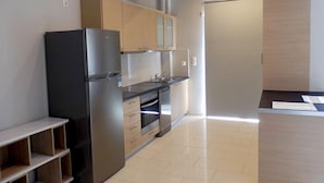 A modern kitchen with a stainless steel refrigerator, wooden cabinets, and a built-in oven. - Geo Maisonette Lagonissi (Saronikos)