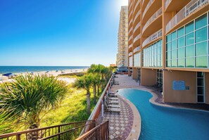 A hotel with a pool, beach view, and a balcony with sun loungers. - Phoenix Gulf Shores 1903! (Gulf Shores)