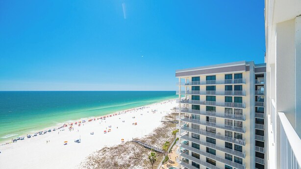 Ein Hochhaus-Hotel mit Blick auf einen Strand und eine klare Sicht auf den Ozean sowie eine Sandküste.
