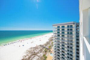 Ein Hochhaus-Hotel mit Blick auf einen Strand und eine klare Sicht auf den Ozean sowie eine Sandküste.