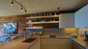 Eine moderne Küche mit Holzelementen, einer integrierten Kochinsel und einer Rückwand mit Mosaikmuster.