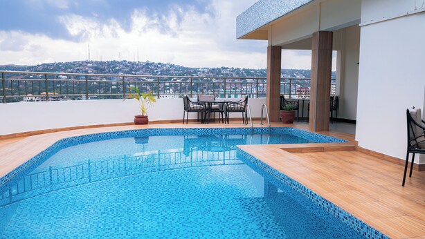 A rooftop swimming pool with a view of a cityscape. - Gold Crest Hotel - Mwanza (Mwanza)