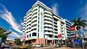 A multi-story hotel with a curved facade, multiple balconies, and a prominent sign indicating it is the "Gold Crest Hotel." - Gold Crest Hotel - Mwanza (Mwanza)
