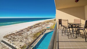 A balcony with a view of a beach and ocean.