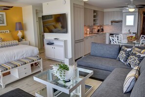A modern living room with a sofa, a glass coffee table, and a TV. - Oceanfront Condo at the Mana Kai Maui, Luxurious, Designer Remodeled (Kihei)