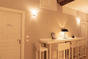 Een moderne keuken met witte kasten, een centraal eiland met barkrukken en hanglampen.