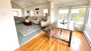 A modern living room with a sofa, coffee table, and dining table. - 9819 Shore - Beachfront on Primehook Beach. (Milford)