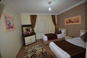 Una habitación de hotel con dos camas, un aparador, un espejo y una lámpara en el techo.