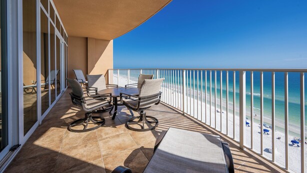 A balcony with a view of the beach, furnished with chairs and a table. - Phoenix Gulf Shores 803 (Gulf Shores)