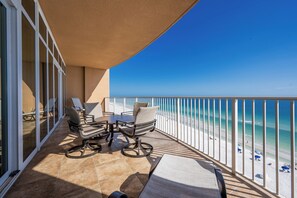 Un balcon donnant sur la plage, aménagé avec des chaises et une table.