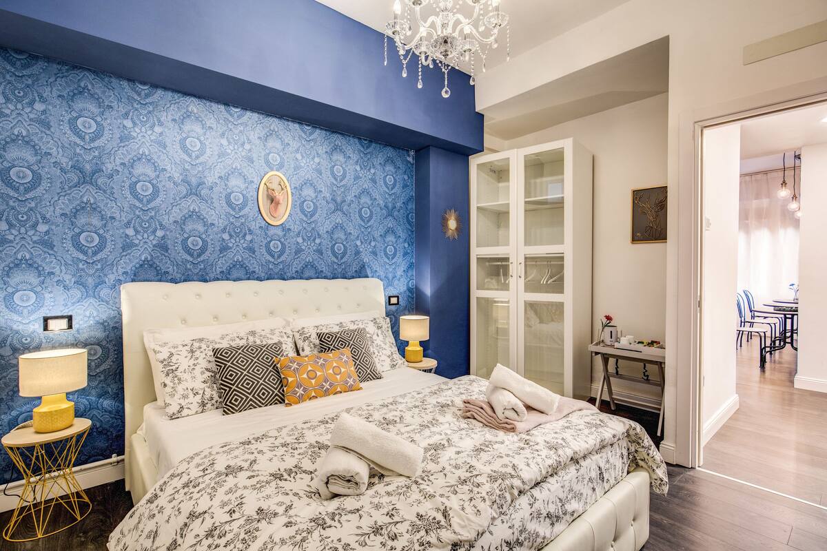 Un dormitorio con una cama grande, una mesita de noche con lámpara y un armario.