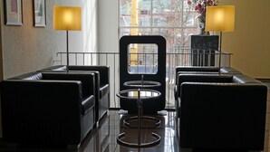 A hotel lobby with leather seating, a central mirror, and two lamps. - Hotel am Stadtgarten (Radolfzell am Bodensee)
