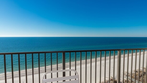 A balcony with a view of the ocean and beach.