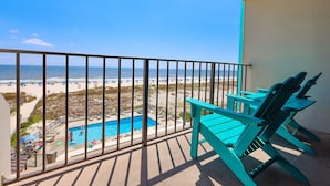 A balcony with a view of a beach and a swimming pool. - PREMIUM! ~ BEACH FRONT ~ 2 Bedroom ~ (Gulf Shores)