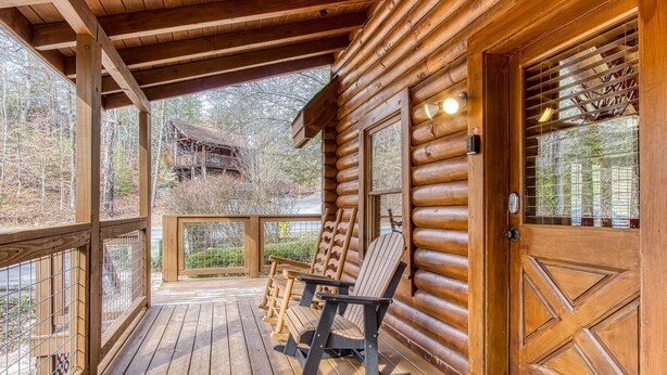 A wooden log cabin with a porch, a rocking chair, and a view of a mountain cabin. - ER45 - Tin Pan Alley - Great location. Just across from swimming pool! (Pigeon Forge)