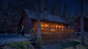 A log cabin with a porch, a stone chimney, and a small staircase leading to the entrance. - ER204 - Dream Catcher  Great location! - Close to town! (Pigeon Forge)