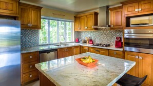 A modern kitchen with wooden cabinets, a stainless steel refrigerator, a microwave, and a coffee maker. - Villa 1: Your Perfect Island Family Retreat (Gros Islet)