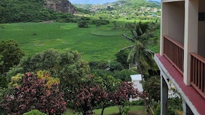 A view from a building with a balcony overlooking a green valley, a mountain, and a clear sky. - Villa 1: Your Perfect Island Family Retreat (Gros Islet)
