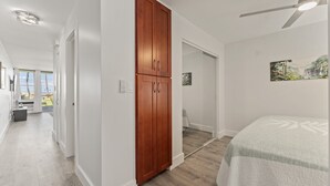 Un dormitorio con cama, armario y ventilador de techo.