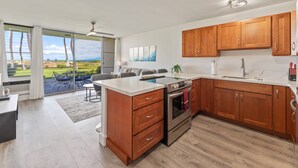 Una cocina moderna con armarios de madera, una isla central y un ventanal con vistas a un jardín.