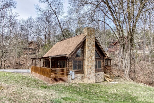 A log cabin with a stone chimney, wooden deck, and a stone staircase leading to the entrance. - ER47 - Moody Blue - Great location. Close to all the action! (Pigeon Forge)