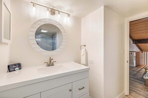 Bathroom features a large mirror above a sink and a makeup station.