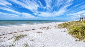 Una playa de arena blanca, cielo azul claro y océano.