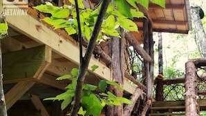 Une structure rustique en bois, dotée d’un escalier en bois et d’une plateforme en bois.