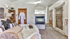 A modern living room with a fireplace, a cozy seating area, and a walk-in closet.