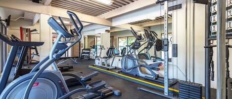 A gym with treadmills, elliptical machines, and weight equipment.