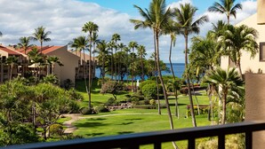 Un resort con varias edificaciones, palmeras y vista al océano.