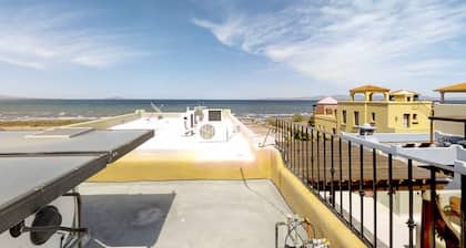 Retiro costero colorido con amplias vistas al mar, gran patio y piscina compartida