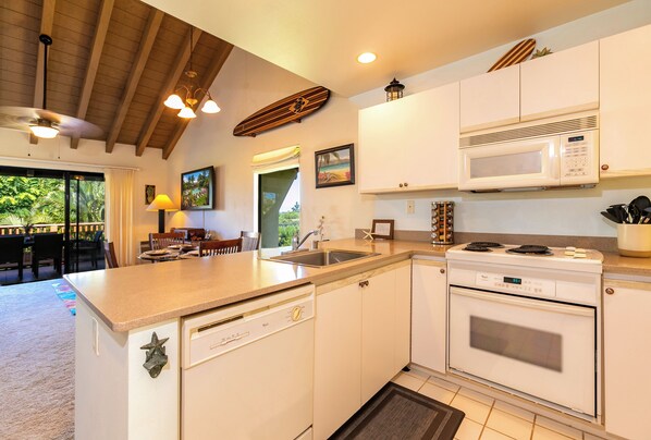 A modern kitchen with white cabinetry, a built-in microwave, and a dishwasher.