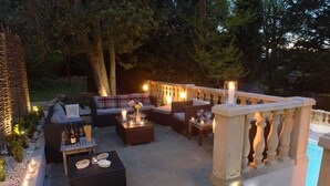 An outdoor patio area with seating, candles, and a pool. - The School Rooms Estate (Corsham)