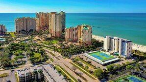 A high-rise hotel complex with multiple buildings, a parking area, and a tennis court. - Beachfront Penthouse at the Apollo!  Best Views on Marco Island! (Marco Island)