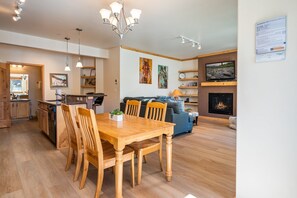 Une cuisine moderne avec des meubles en bois, une table à manger avec des chaises et un four encastré.