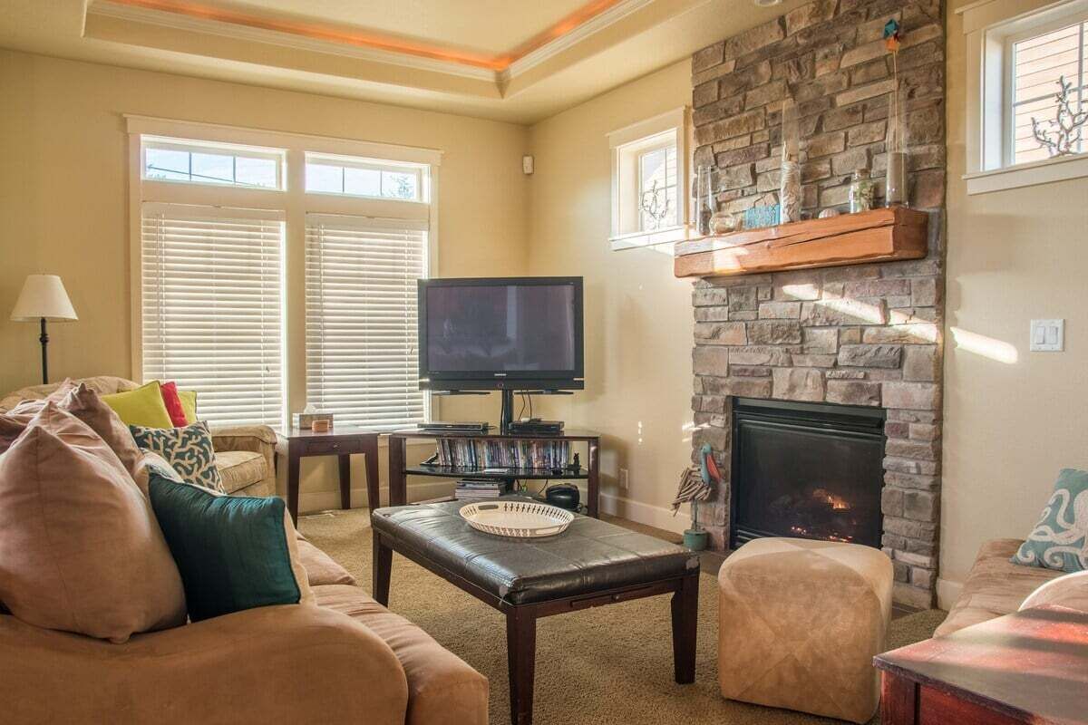 A living room with a fireplace, a television, and a sofa.