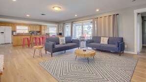 Un salon moderne avec un canapé gris, une table basse et un tapis à motifs.