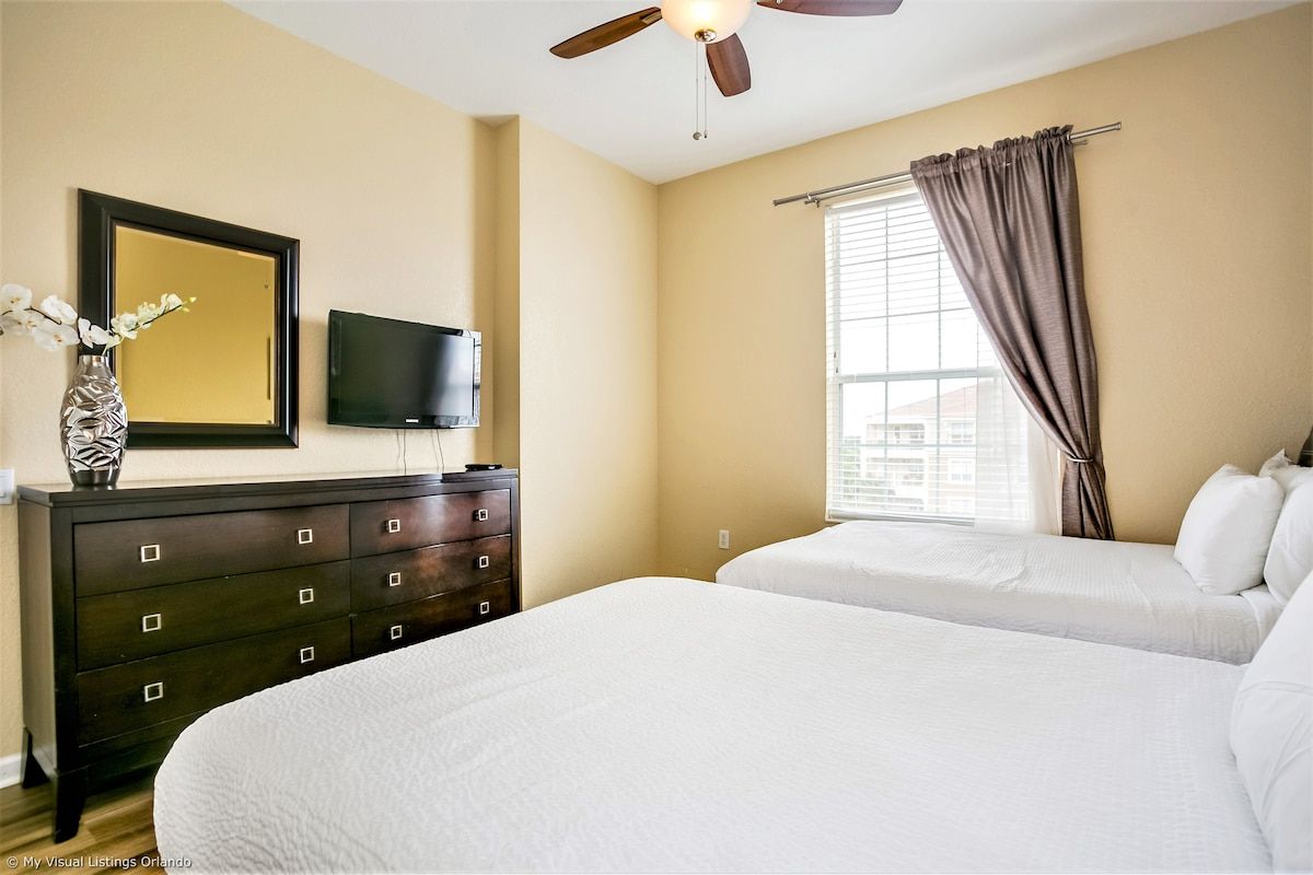 Shared Serenity: This bedroom with two beds offers a tranquil space for companionship and relaxation, where shared dreams and cherished moments intertwine amidst comfort and warmth.