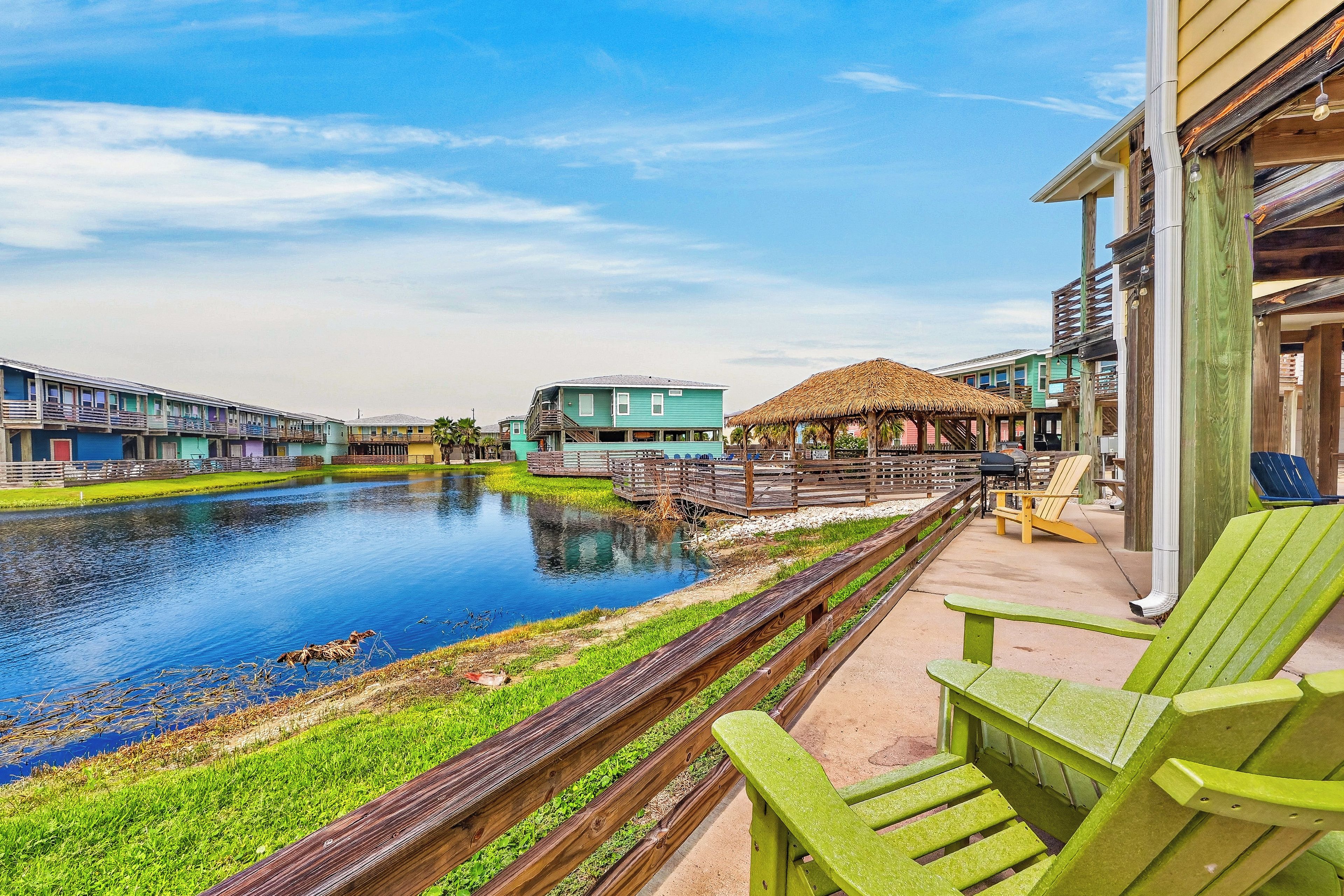 Waterfront property offering peaceful lagoon views with colorful resort buildings and communal outdoor spaces perfect for relaxation.