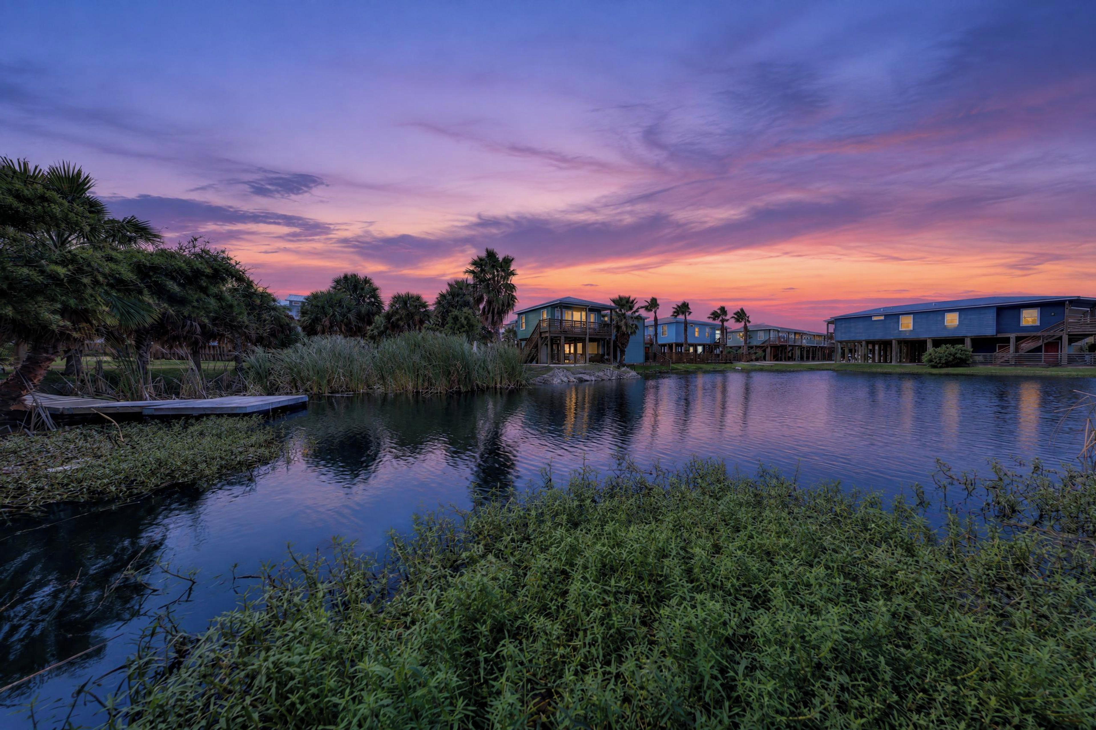 A waterfront property with multiple buildings, a dock, and a calm lake.