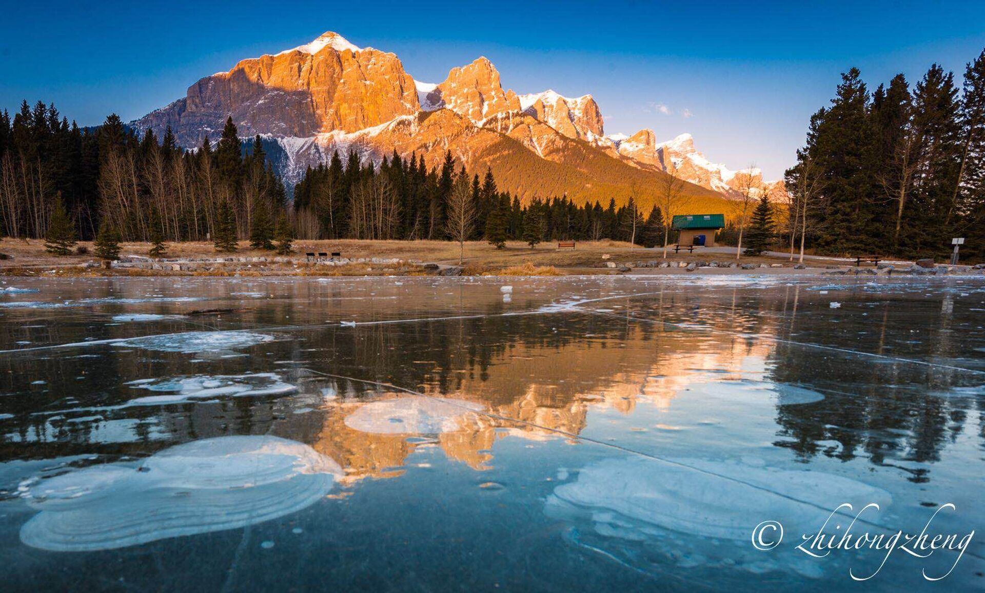 Un lago congelado con montañas al fondo.