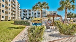 A hotel with a sign indicating 'Key West' and 'To the Beach' directions. - Emerald Coast Vibes & Sunset Views – Islander 517 (Destin)