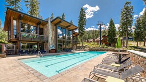 A modern building with a pool and lounge chairs. - Gondola Ski-in/Ski-out By Tahoe Getaways - Luxury 4 BR, Private Hot Tub, Access to Pool (Truckee)
