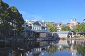 A waterfront hotel with a dock, a covered walkway, and a building with a sign. - 4BR Beach Villa w/ 2 GOLF CARTS! Near Pool & Wharf. Beach Tram. Covered Patio (Miramar Beach)