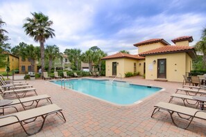 A pool area with lounge chairs and a small building with a tiled roof. - 4BR Beach Villa w/ 2 GOLF CARTS! Near Pool & Wharf. Beach Tram. Covered Patio (Miramar Beach)