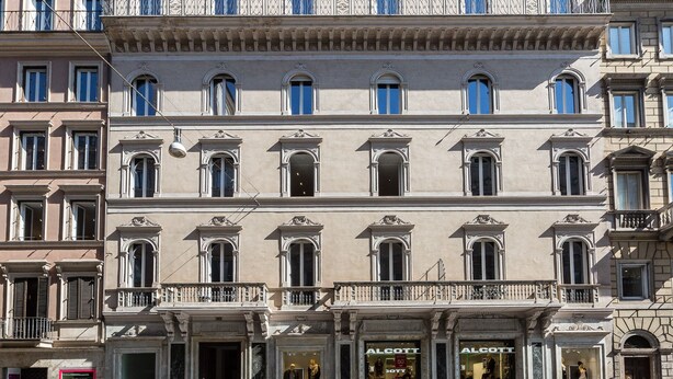 Un edificio de varios pisos con un estilo arquitectónico clásico, que presenta balcones ornamentados y ventanas de arco.