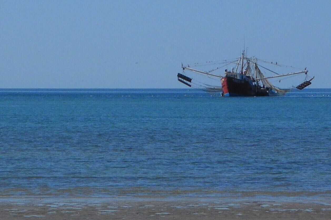 Um barco de pesca encalhado na água.